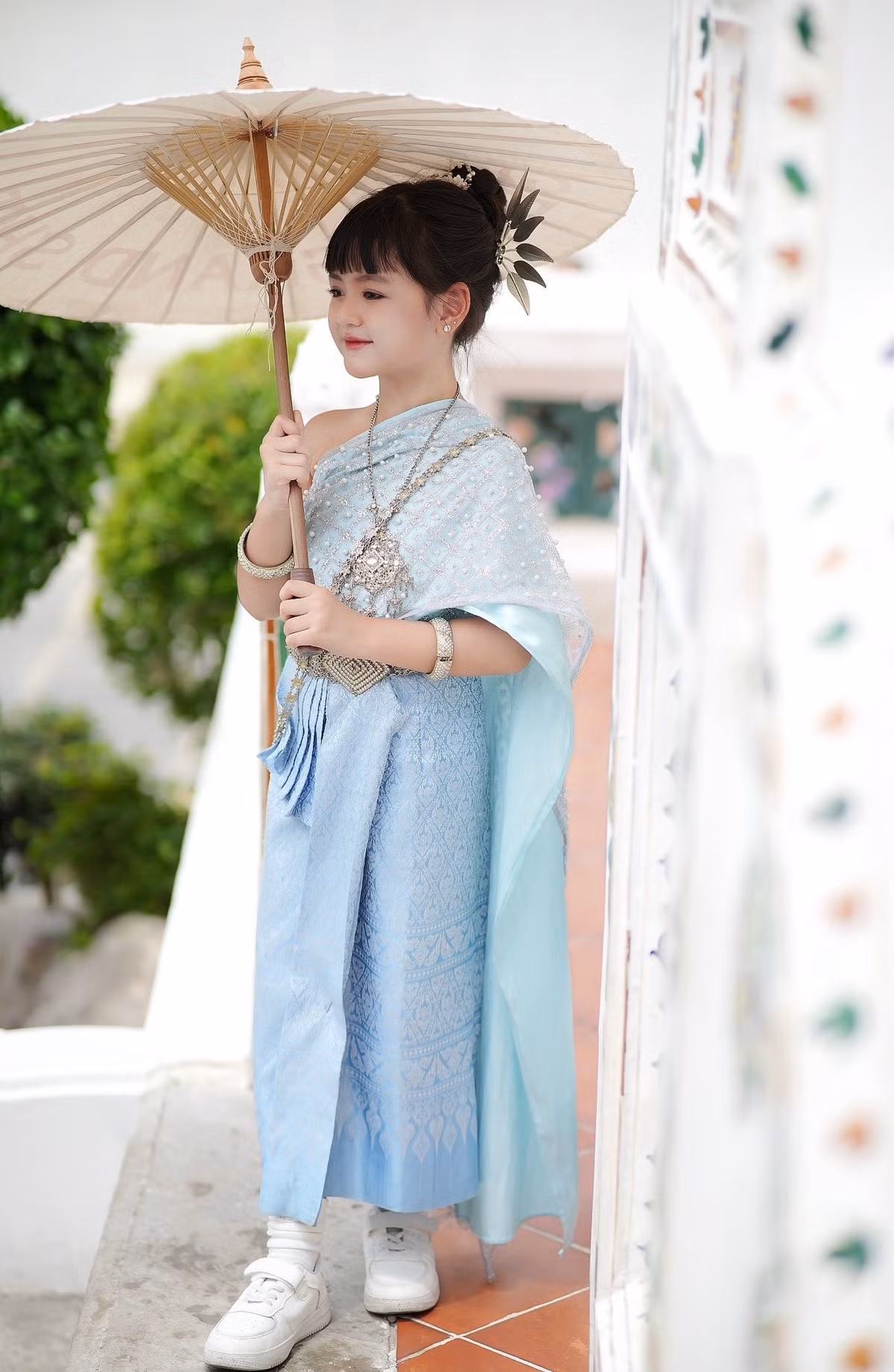 Chất liệu lụa dệt hoa văn cầu kỳ, kết hợp với chiếc khăn vắt qua vai mềm mại đã tạo nên sự nữ tính, yểu điệu. (Ảnh: FBNV)