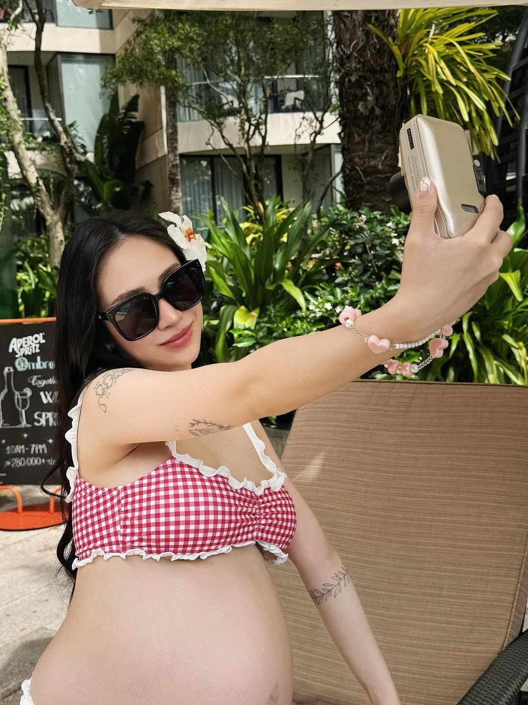 Cô không ngần ngại tạo dáng bên hồ bơi và khu vực quầy bar, thể hiện sự thoải mái và tận hưởng những khoảnh khắc cuối cùng của hành trình mang bầu.