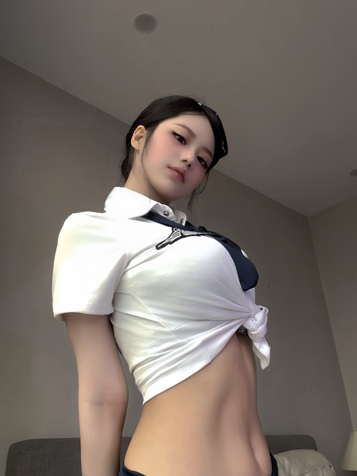 Trong bộ ảnh, YuGi diện trang phục tiếp viên hàng không truyền thống với áo sơ mi trắng và chân váy bút chì màu xanh navy. (Ảnh: FBNV)