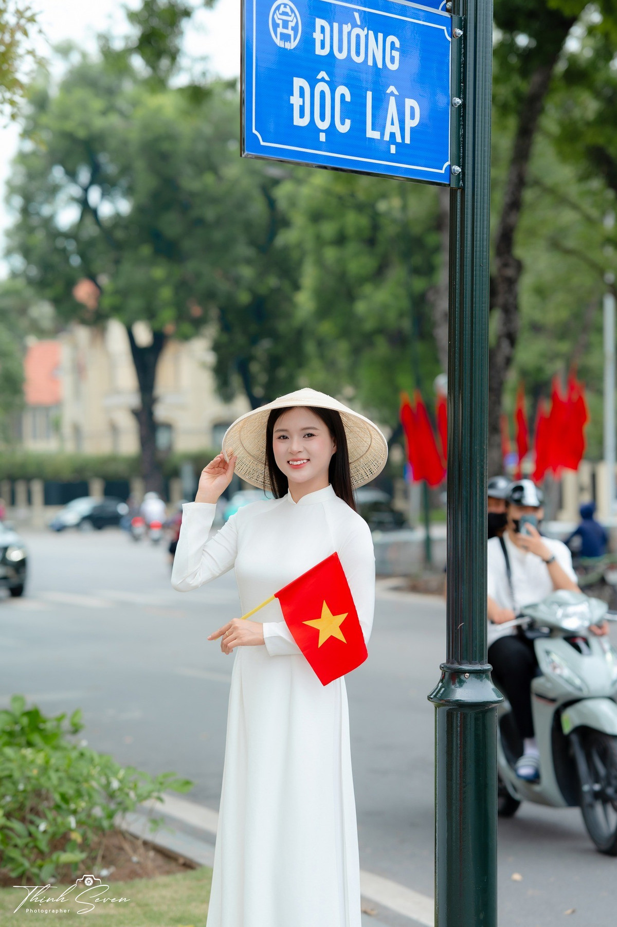 Trang phục áo dài trắng truyền thống cùng những phụ kiện như lá cờ nhỏ, nón lá được giới trẻ ưa chuộng vì dễ kết hợp với nhiều bối cảnh và "toát lên tinh thần dân tộc". (Ảnh: Facebook Thịnh Seven)