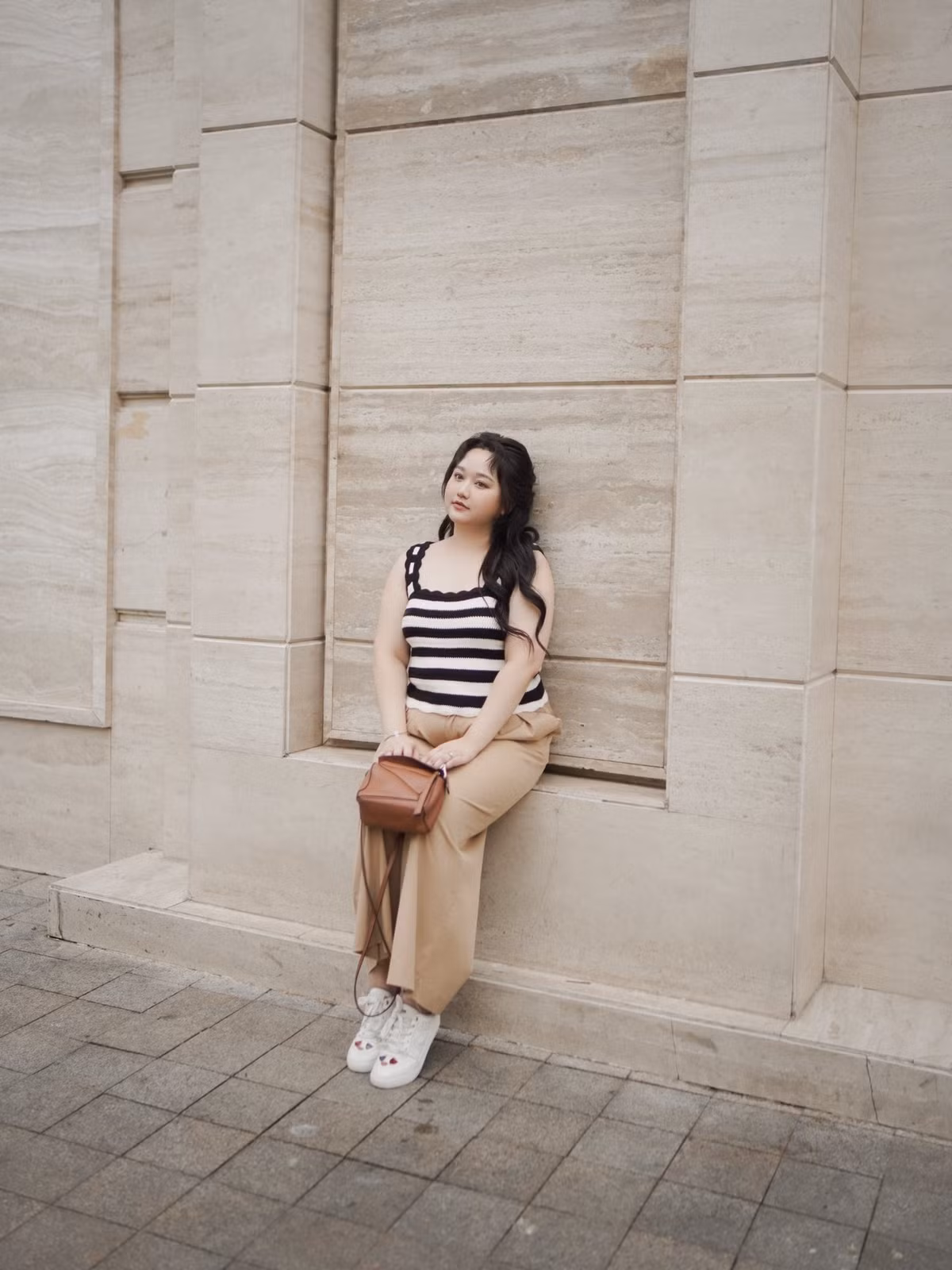 Phong cách thời trang trong những hình ảnh mới cho thấy Trúc Anh đã chọn hướng đi giản dị, thoải mái hơn. Bộ trang phục áo len sọc đen trắng kết hợp quần âu be, túi xách da nâu và giày thể thao trắng thể hiện sự tự tin và yêu thương bản thân ở hiện tại.