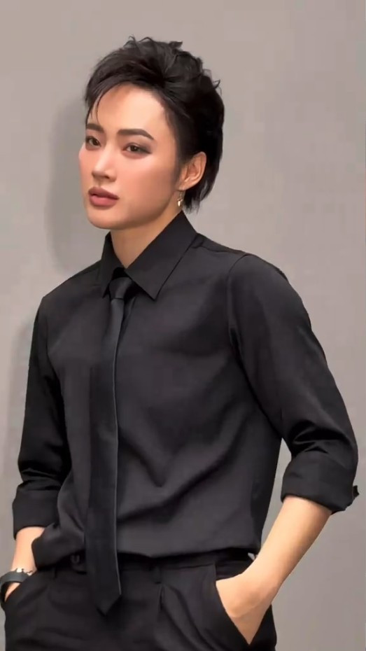 Mái tóc pixie được vuốt gọn gàng, phụ kiện nam tính như đồng hồ, khuyên tai kim loại tạo nên một tổng thể vừa mạnh mẽ, cá tính, vừa toát lên vẻ quyền lực, bí ẩn.