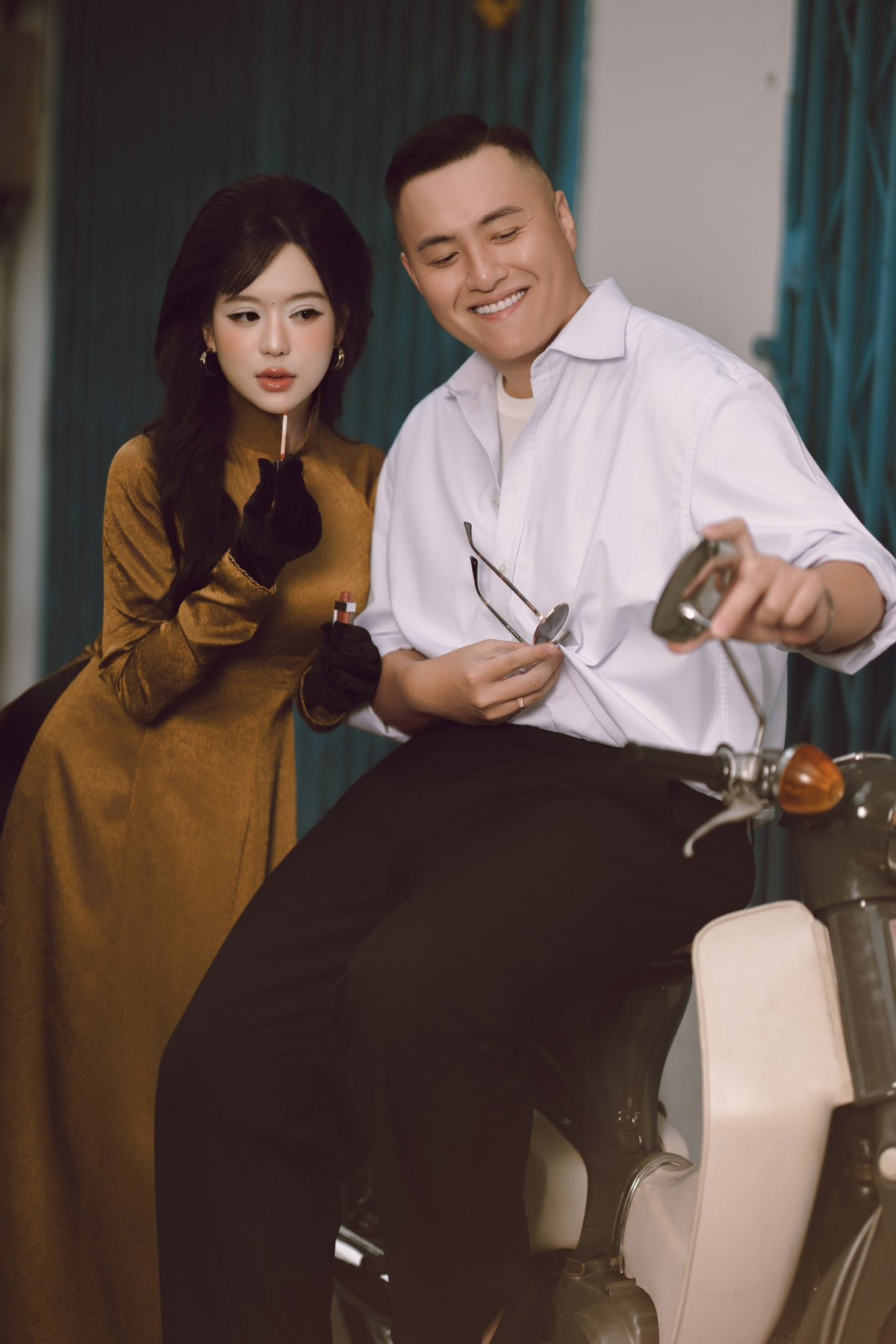 Đặc biệt, chi tiết mợ hai mượn gương xe máy để... dặm lại son, còn cậu ba thì cười hiền hậu chiều lòng vợ, đã khiến người xem không khỏi thích thú vì sự hóm hỉnh và đáng yêu. (Ảnh: IG @vantiny.ng)