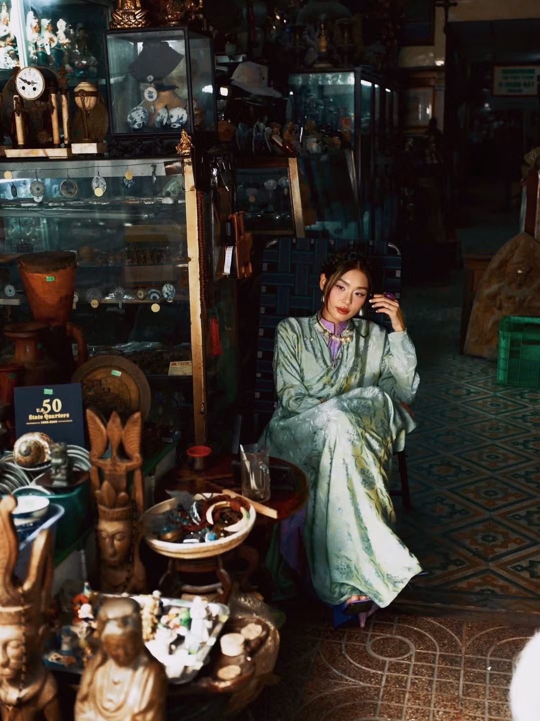 Cô diện thiết kế áo dài gấm cách tân tông xanh cốm nhã nhặn, với phần cổ kép gồm phần cổ ngoài hơi trễ, kết hợp cùng phần cổ áo cao truyền thống màu tím nhạt bên trong tạo điểm nhấn tương phản thú vị. Chất liệu gấm bóng với họa tiết in chìm giúp tôn lên vẻ sang trọng, quyền quý. (Ảnh: IGNV)