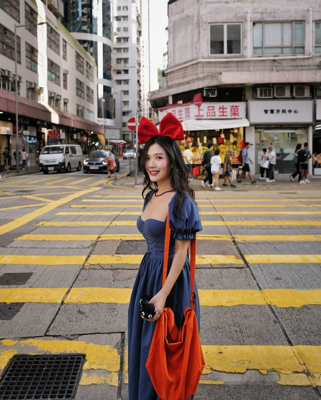 Trong những bức ảnh đường phố, Chù Distubia còn khéo léo tạo dáng ở những góc máy giống hệt các phân cảnh trong phim, từ băng qua vạch kẻ đường đến đứng cạnh quầy tạp hóa, tạo nên một sự hòa quyện thú vị giữa thế giới anime và đời thực. (Ảnh: FBNV)