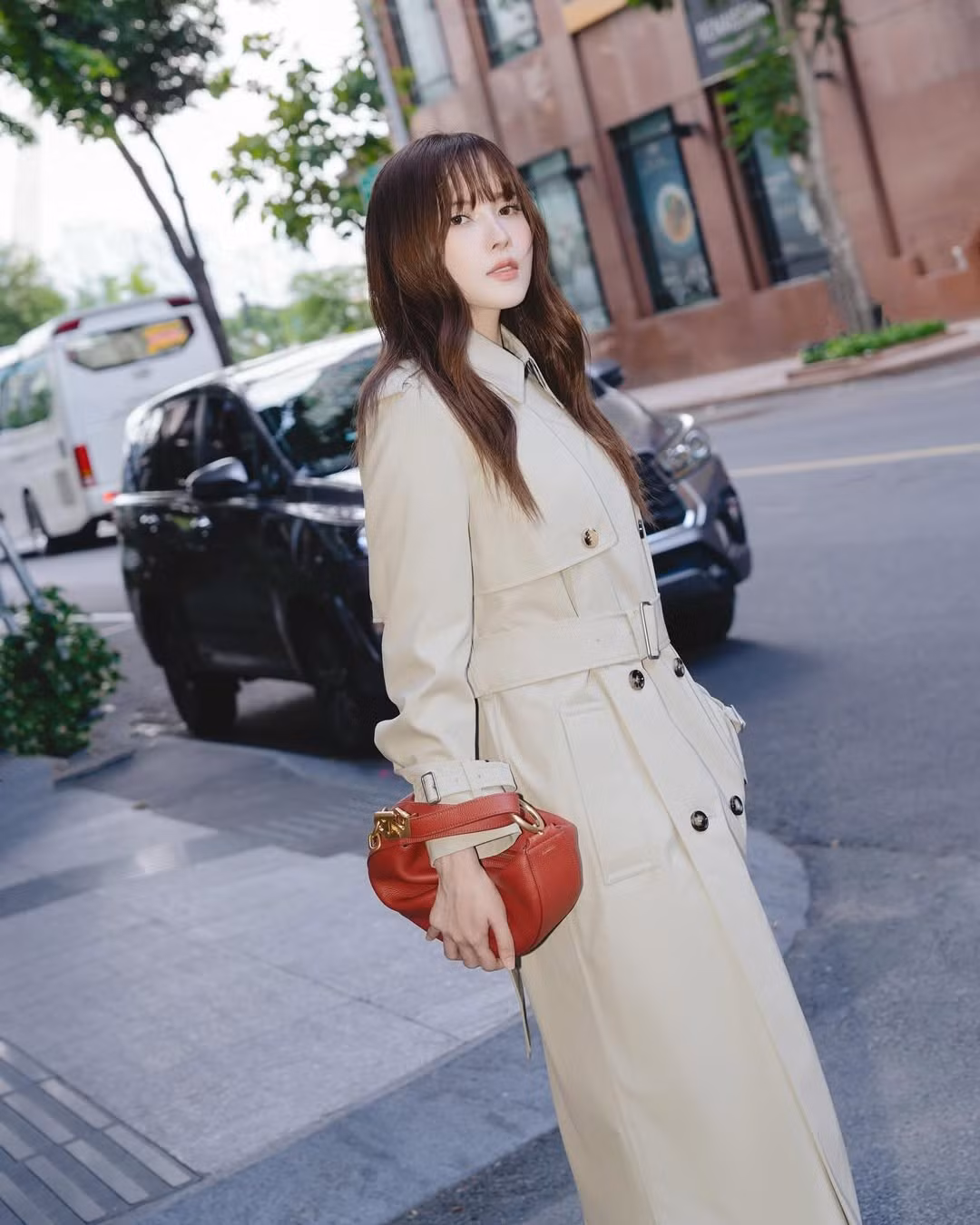 Áo cape tay lửng phối cùng chân váy ngắn và túi xách họa tiết tartan gợi lên phong thái quý cô châu Âu, vừa thời thượng vừa mềm mại.