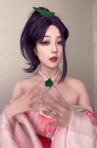 Trang phục mà Kiittwy lựa chọn hóa thân mang phong cách yểu điệu, thướt tha với tông màu hồng và trắng chủ đạo, cùng điểm nhấn là mái tóc tím nổi bật và các phụ kiện màu xanh ngọc. (Ảnh: IGNV)