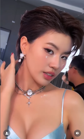 Điểm nhấn trên tổng thể trang phục là chuỗi dây chuyền kim loại nhiều lớp, phối hợp với mặt dây hình ngôi sao và thánh giá, tạo nên sự cân bằng hoàn hảo giữa vẻ ngoài nữ tính và tinh thần cá tính, bụi bặm đặc trưng của giới rapper. (Ảnh: IGNV)