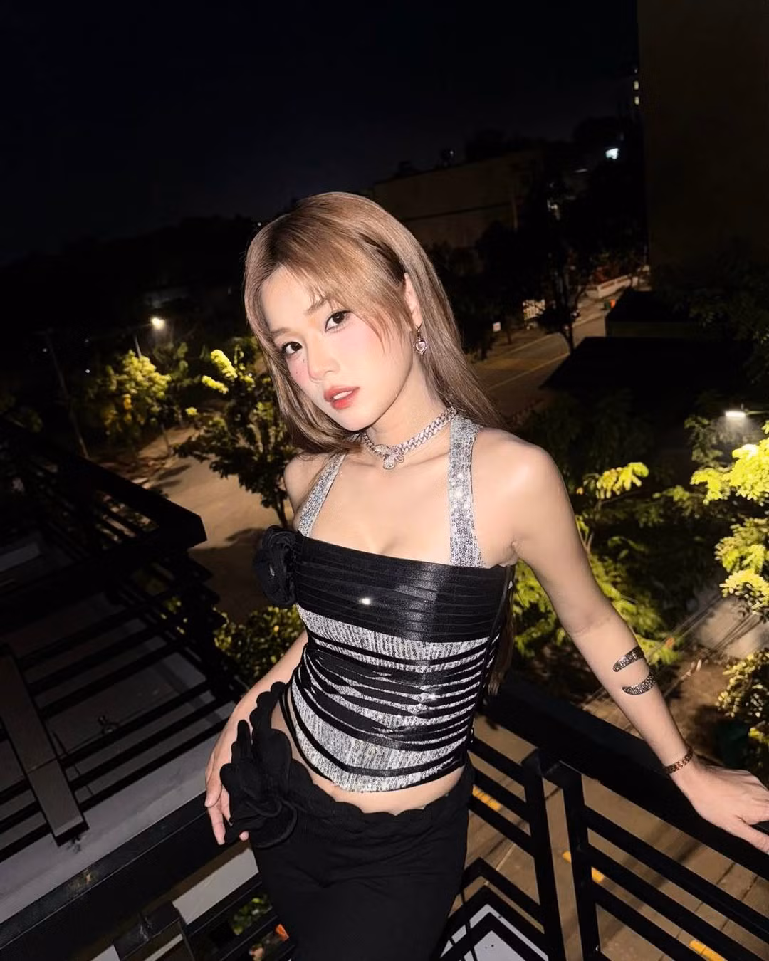 Bộ trang phục gồm áo ánh kim kết hợp chất liệu đan dây và chi tiết hoa 3D độc đáo giúp khoe trọn vòng eo nhỏ gọn cùng bờ vai thon.