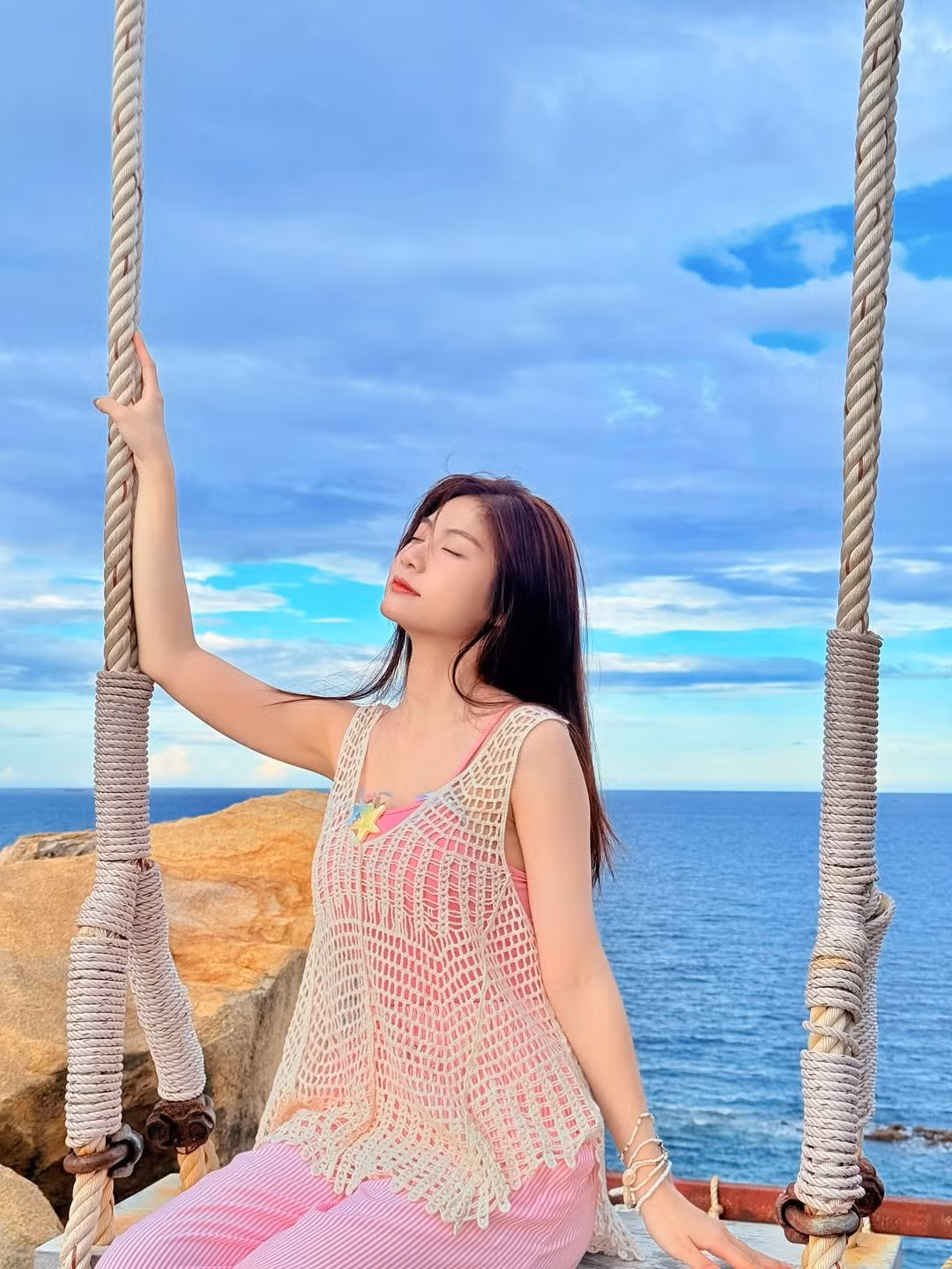 Set đồ nhẹ nhàng với áo hai dây và quần kẻ sọc, tạo nên vẻ ngoài năng động nhưng không kém phần dịu dàng. Điểm nhấn là chi tiết trang trí nhỏ xinh trên áo, khiến tổng thể trở nên đáng yêu hơn.