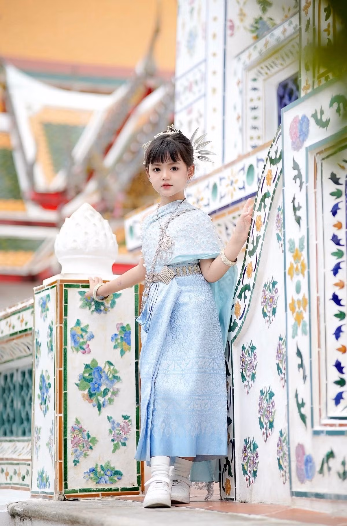 Trong bộ ảnh này, An Nhiên dường như đã hóa thân thành một nàng công chúa nhỏ bước ra từ cổ tích, mang theo nét trong trẻo nhưng cũng đầy tự tin giữa không gian cổ kính, rực rỡ sắc màu ở Thái Lan. (Ảnh: FBNV)