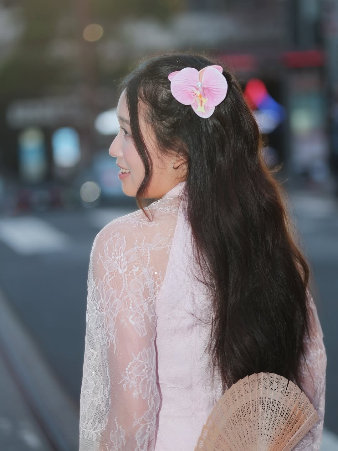 Kết hợp cùng phụ kiện là một chiếc quạt gỗ chạm khắc và đóa hoa lan cài tóc cùng tông màu, Jenny Huỳnh hiện lên với vẻ ngoài trong sáng, thanh lịch nhưng vẫn không kém phần tinh nghịch đặc trưng. (Ảnh: IGNV)