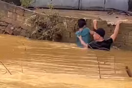 Người đàn ông lao xuống dòng lũ dữ cứu học sinh bị nước cuốn trôi