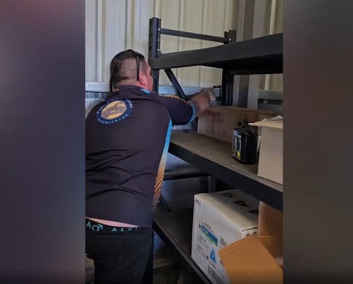 Chuyên gia bắt rắn chuyên nghiệp Daniel May, 34 tuổi, đã nhận được cuộc gọi đến một ngôi nhà ở Rossmore, Australia để bắt con rắn đen bụng đỏ khổng lồ trốn sau tủ lạnh trong nhà kho. Ảnh cắt từ clip.