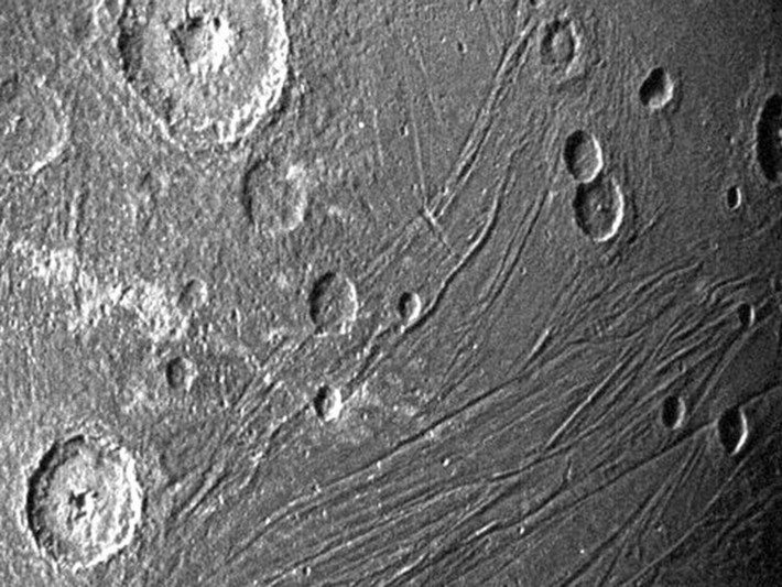 Cận cảnh phía tối của mặt trăng Ganymede. NASA tin rằng bên dưới lớp vỏ của vệ tinh này có chứa nước đóng băng, muối khoáng và các hợp chất hữu cơ.