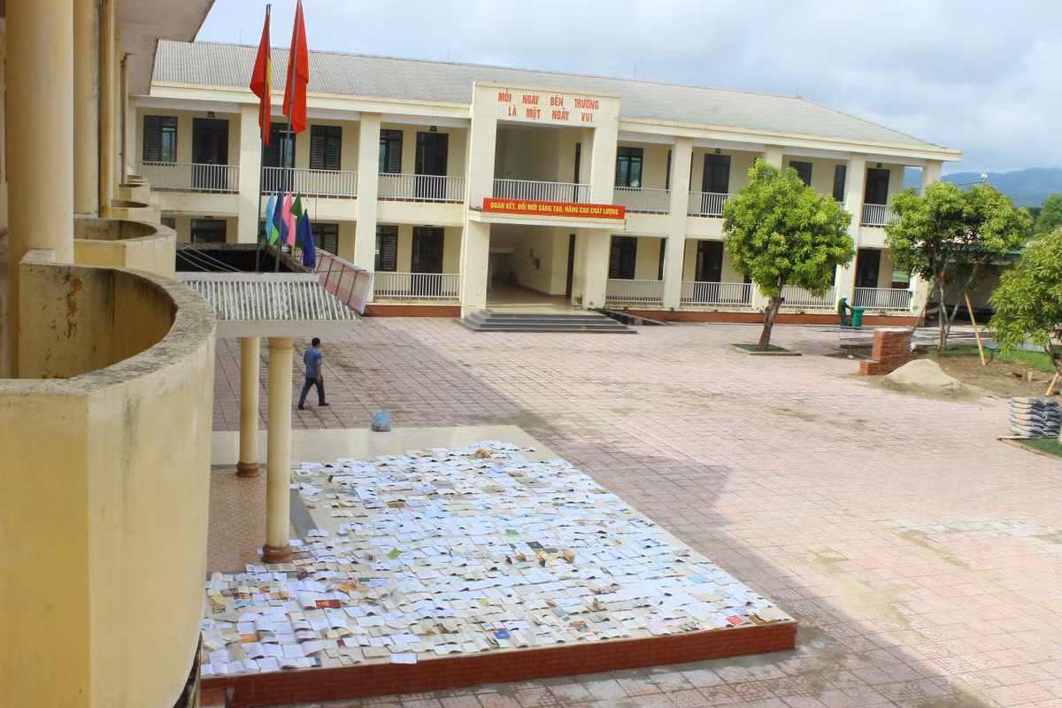 Tranh thủ thời tiết nắng ráo, các cô giáo trường THCS Sơn Lộc lật dở từng trang sách để hong phơi cho học sinh.