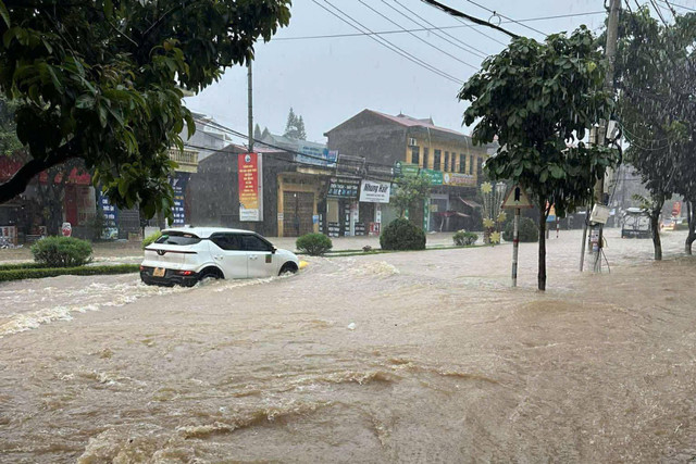 Nước ngập gần hết bánh xe ô tô sau trận mưa lớn. Ảnh: D.Q lang-son6.jpg