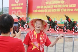 Cụ bà 99 tuổi phấn khởi chụp ảnh cùng pháo lễ ở Mỹ Đình