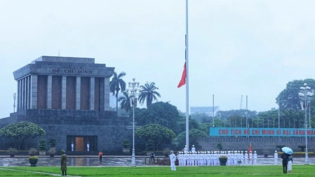 Bộ Tư lệnh Bảo vệ Lăng Chủ tịch Hồ Chí Minh thực hiện nghi lễ treo băng tang lên quốc kỳ và thượng cờ rủ tại Quảng trường Ba Đình sáng sớm ngày 24/5, , bắt đầu Quốc tang nguyên Chủ tịch nước Trần Đức Lương. Ảnh: TTXVN 1.jpg