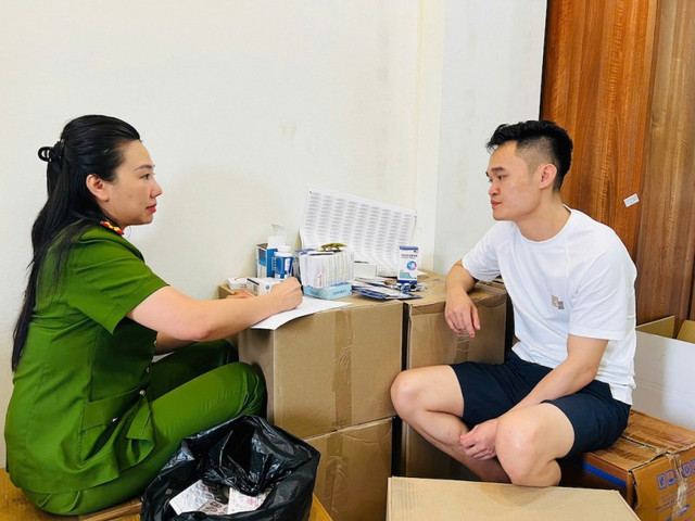 Cán bộ Công an TP Hà Nội làm việc với đối tượng Phạm Ngọc Tiến. 89999977.jpg