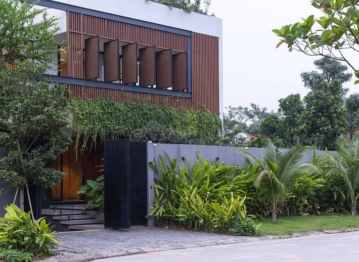Khác với những căn biệt thự thường thấy tại địa phương - nơi nhà chiếm phần lớn đất, kiến trúc sư chọn lùi khối nhà về phía trong lô đất, nhường mặt ngoài làm sân vườn, hồ bơi và khoảng đệm. Ảnh: Triệu Chiến