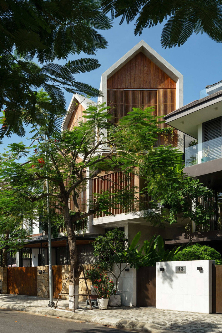Hệ lam gỗ chắn nắng, đóng mở linh hoạt, kết hợp cùng mảng cây xanh đa dạng tạo sự chuyển động thú vị qua các thời điểm trong ngày và hài hòa với cảnh quan xung quanh. Ảnh: Quang Trần