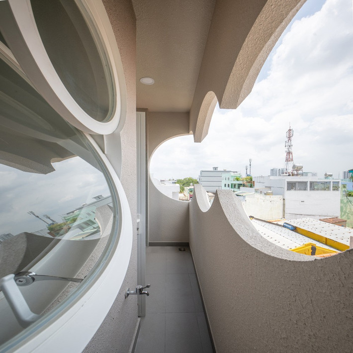 Điểm đặc biệt của ngôi nhà nằm ở các ô cửa hình tròn và hình đám mây mềm mại, vừa lấy sáng, thông gió, vừa tạo nên hiệu ứng thị giác đẹp mắt. Ảnh: Sonmeo Nguyen Art Studio
