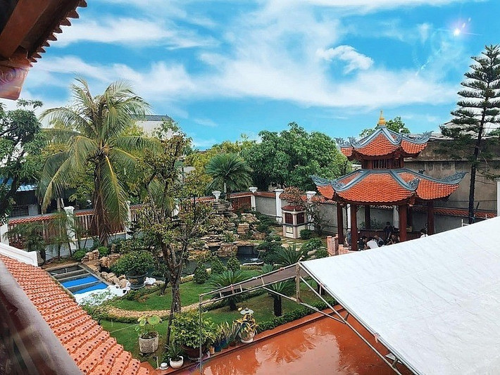 Công trình được xây trên khu đất rộng 900m2, bao gồm một căn nhà gỗ 5 gian, một gian nhà sinh hoạt chung rộng, cùng khoảng sân vườn và hồ cá bao quanh. Ảnh: Người quan sát