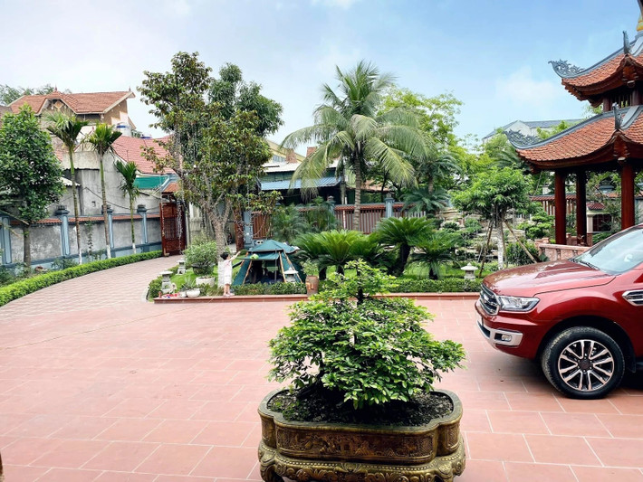 Bên ngoài là khoảng sân rộng, gồm một chòi lục giác chồng diêm đặt ngay cạnh hồ cá Koi. Ảnh: Happynest