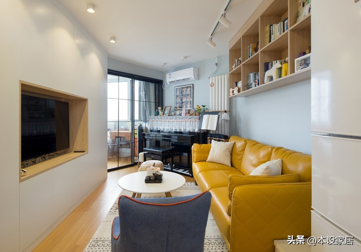 Phòng khách tối giản nhưng có điểm nhấn với sofa màu cam kết hợp tủ gỗ âm tường. Ảnh: Sohu