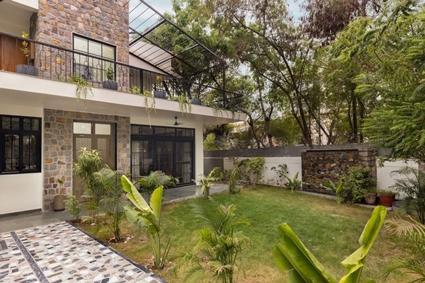 Mảnh đất có hướng Đông Bắc, một khu vườn phía trước bắt buộc, và những hàng cây đã đứng vững từ lâu trước khi bất kỳ bản vẽ nào được thực hiện. Ảnh: Purnesh Dev Nikhanj
