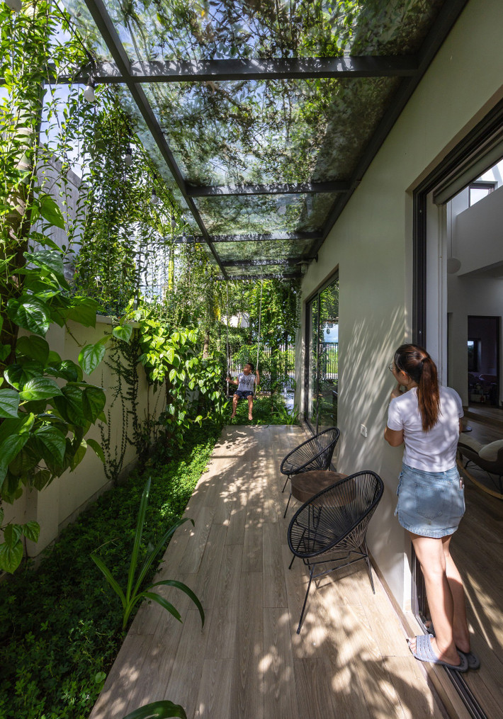 Hiên nhà được che phủ bằng mái kính trong suốt, bên trên phủ cây leo tạo bóng mát tự nhiên, đồng thời cho phép ánh sáng nhẹ nhàng xuyên qua. Ảnh: Triệu Chiến