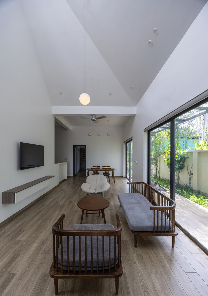 Hệ cửa kính lớn sát sàn mở ra khoảng hiên xanh mát, kết nối liền mạch giữa bên trong và ngoài. Ảnh: Triệu Chiến
