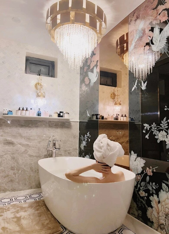 Phòng tắm rộng rãi với bồn sứ sang trọng và hệ thống đèn trần pha lê. Ảnh: FBNV