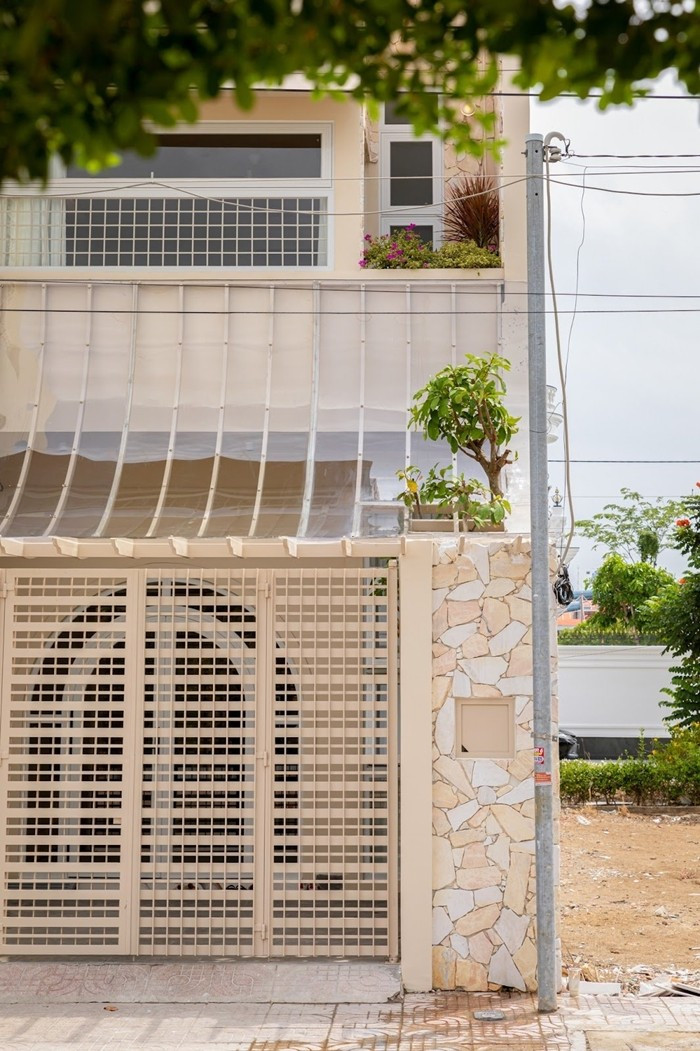 Mặt tiền ngôi nhà nổi bật với đường cong mềm mại, lớp lưới chắn trong suốt và chất liệu đá tự nhiên. Ảnh: Da Vàng studio