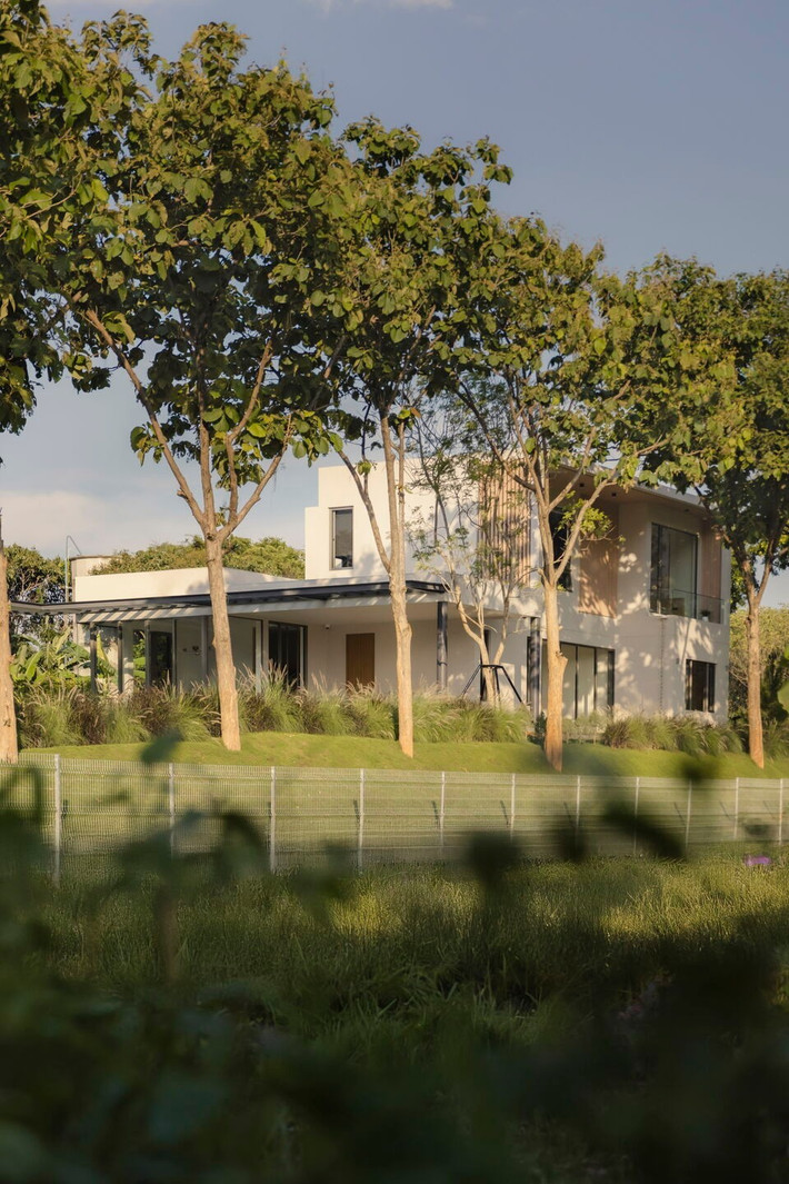 Nằm trên một khu đất cao đầy nắng gió tại huyện Pak Chong, tỉnh Nakhon Ratchasima (Thái Lan), ngôi nhà 2 tầng như một giấc mơ an yên giữa rừng núi và ruộng đồng. Ảnh: Archello