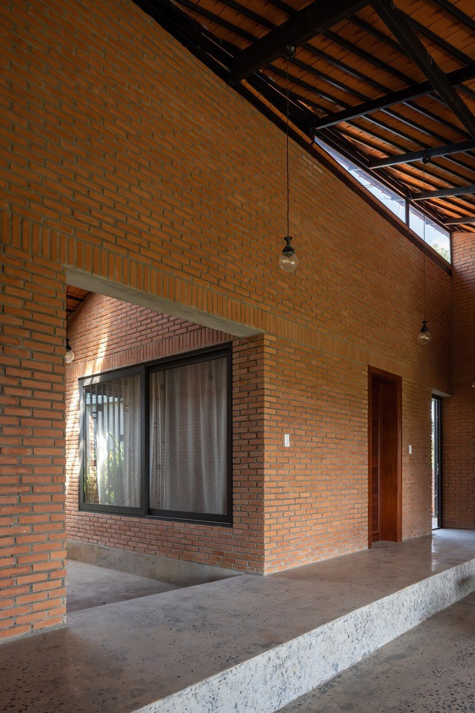 Một bức tường gạch dài chạy dọc theo khu đất được hình thành, phân chia không gian ở và sinh hoạt. Ảnh: Hoang Le