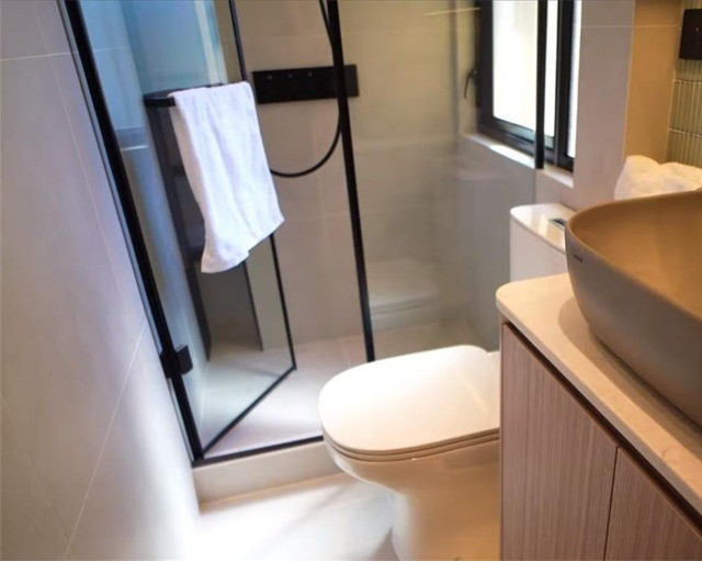 Đối diện bếp là phòng vệ sinh với thiết kế cửa lùa dạng ẩn để tiết kiệm diện tích. Bên ngoài là bồn rửa mặt, bên trong gồm toilet và buồng tắm đứng ngăn cách bằng cửa kính. Ảnh: Toutiao
