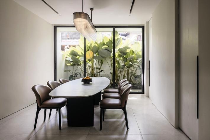 Bàn ăn nằm sát sân sau, hướng tầm nhìn ra khu vườn nhỏ xanh mát. Ảnh: Studio Periphery