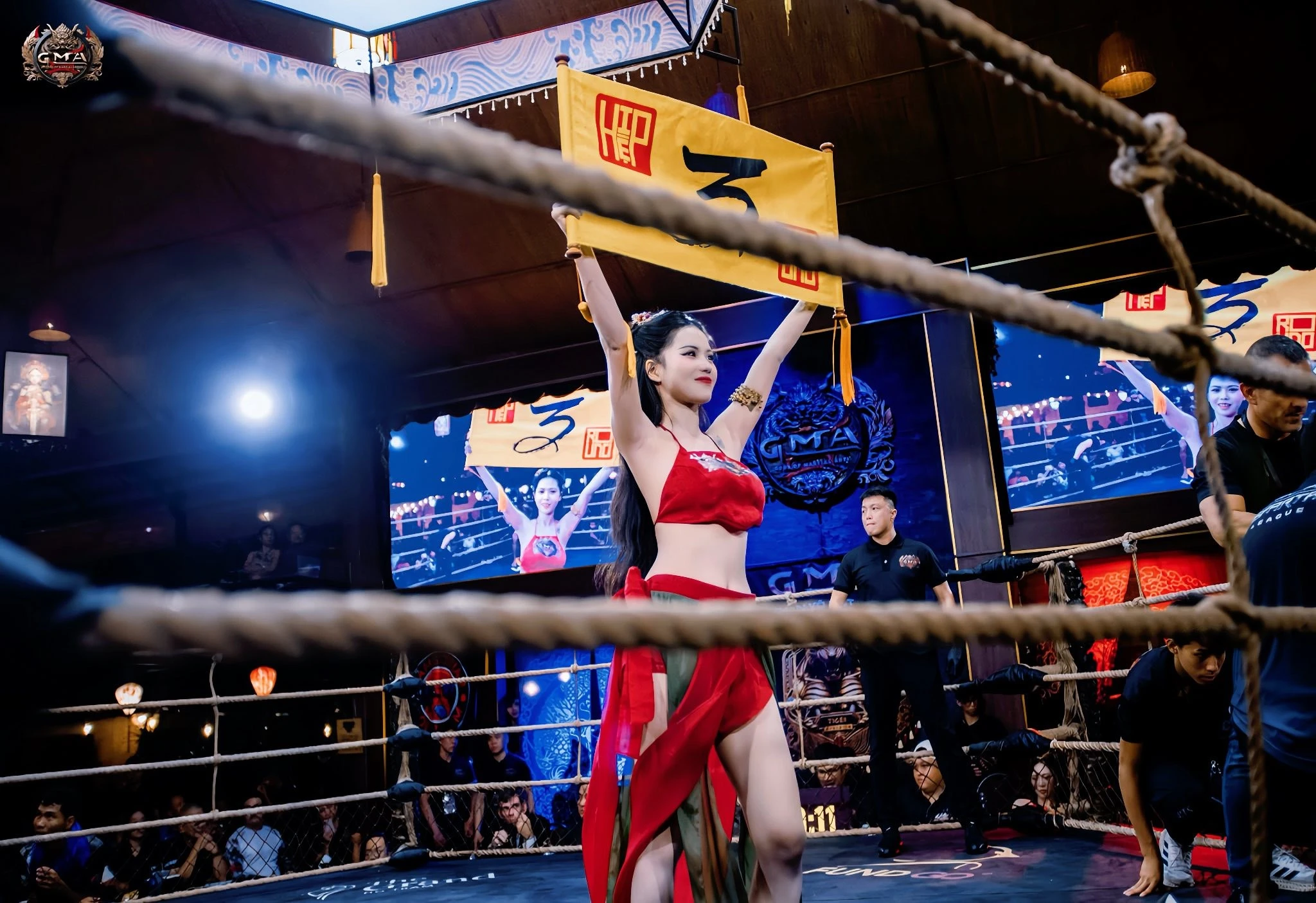 Nữ cosplayer Nguyễn Hữu Kiều Oanh diện áo yếm cầm biển tại sàn MMA