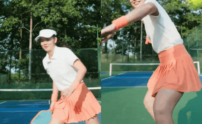 Ánh Viên xuất hiện với outfit áo phông trắng kết hợp váy tennis cam rực rỡ, nhan sắc xinh đẹp ngọt ngào, tay cầm vợt nở nụ cười rạng rỡ, nhẹ nhàng mà thần thái thì vẫn "rất gì và này nọ" trong clip mới khi tham gia bộ môn vô cùng hot là pickleball.