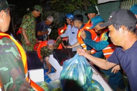 Bộ đội hỗ trợ người dân di chuyển ra khỏi khu vực ngập sâu lúc rạng sáng 5/12.