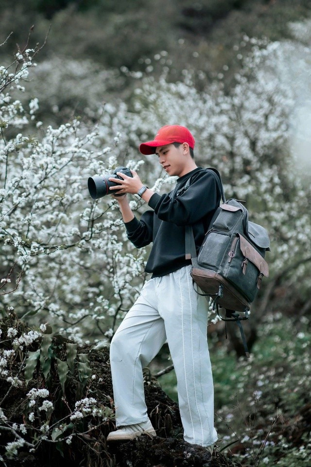 Xuân Thăng tác nghiệp chụp ảnh cho du khách tại vườn mận ở Mộc Châu (Ảnh: NVCC).