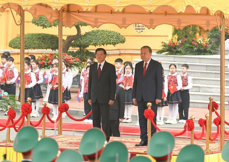 Tổng Bí thư Tô Lâm và Tổng Bí thư, Chủ tịch nước Lào Thongloun Sisoulith trên bục danh dự, thực hiện nghi thức chào cờ - Ảnh: VGP/Nhật Bắc
