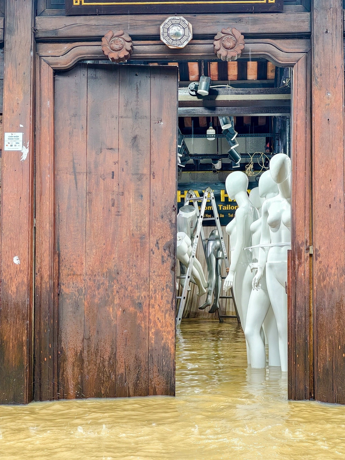 Anh Nguyễn Hải (người dân địa phương) cho biết phần lớn các hộ kinh doanh bên trong khu phố đã sơ tán, chỉ còn vài người túc trực để khi nước rút thì dọn bùn non trong nhà. Ảnh: Phạm Phùng.