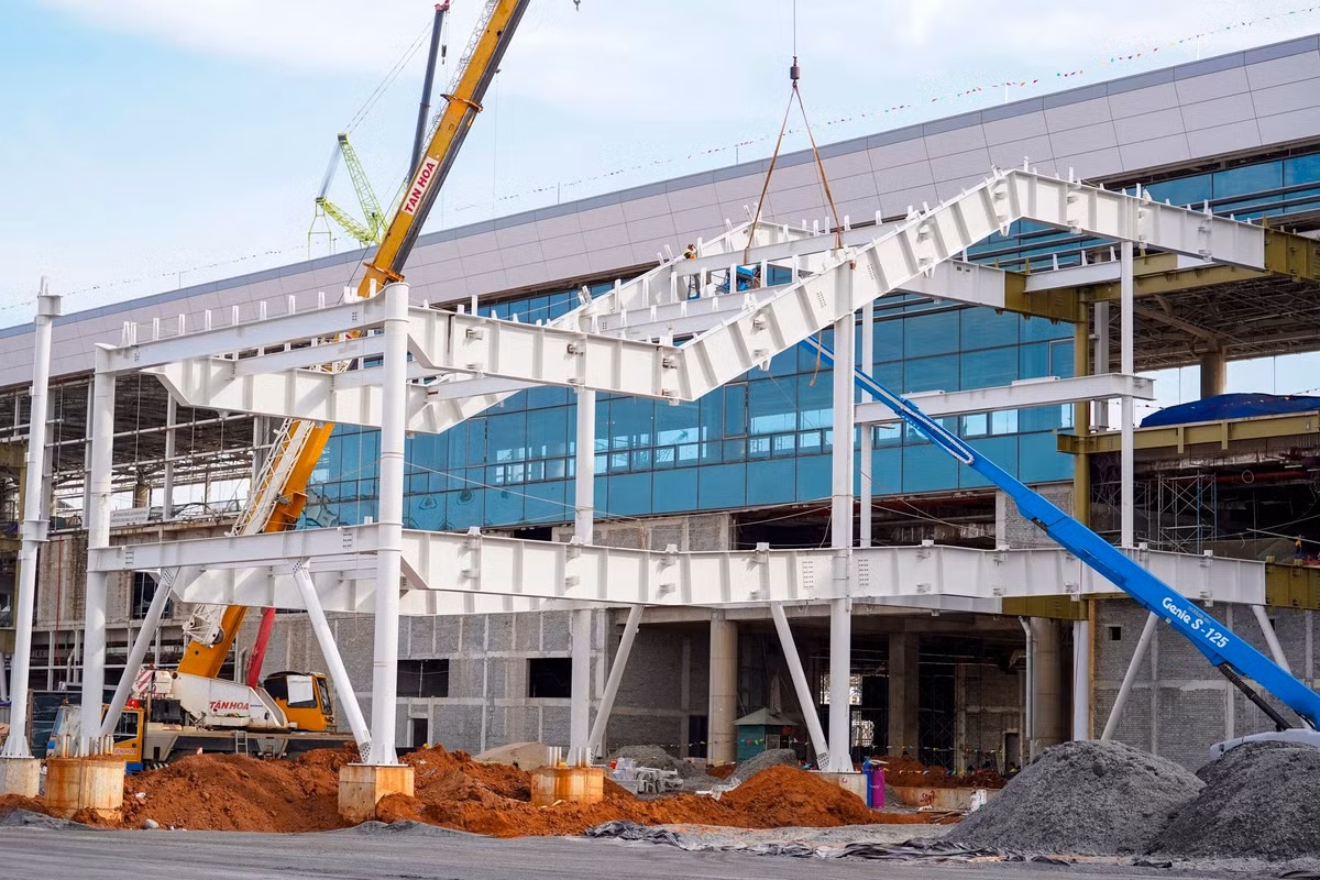 Trong ảnh là hạng mục cầu ống lồng cố định kết nối nhà ga hành khách và sân đỗ máy bay đang được thi công khẩn trương.