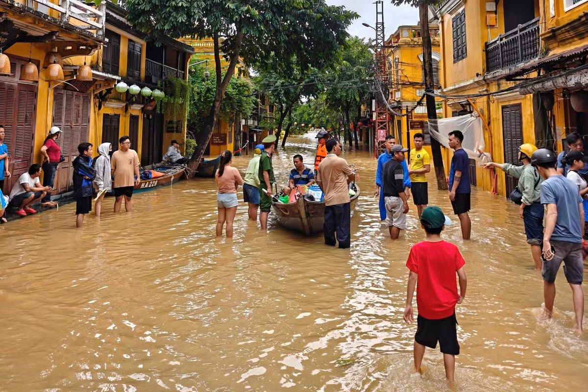 Tại điểm giáp ranh giữa vùng ngập và khu vực khô ráo, nhiều người dân tập trung để đón thuyền mua lương thực hoặc nhận tiếp tế. Ảnh: Hải - Trải Nghiệm.