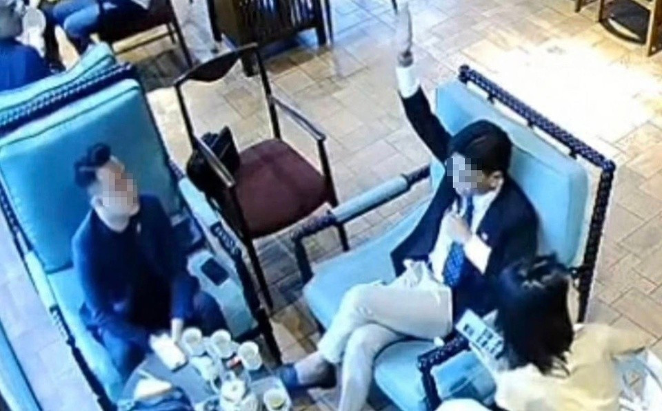 N.L.V. (áo đen) vẫn đang bị tạm giam sau khi hành hung con trai chủ quán cà phê hôm 17/9. Ảnh cắt từ clip.