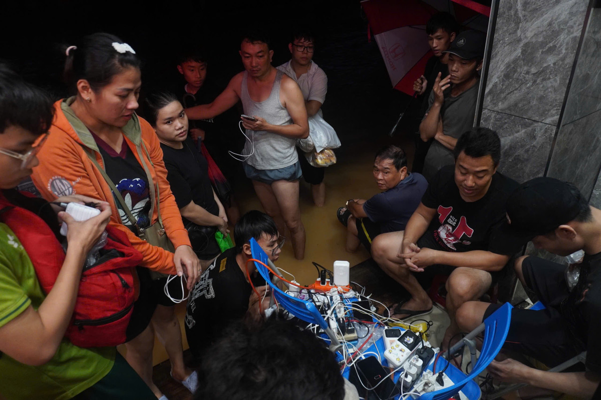 Người dân gần đó tranh thủ sạc các thiết bị điện ở cửa hàng thực phẩm cao có máy phát điện. Hiện, TP Huế đã mất điện 3 ngày. Theo cơ quan khí tượng thành phố, 5h sáng, lũ sông Bồ tại Phú Ốc (Huế) xuống dưới báo động ba 0,05 m. Địa phương tiếp tục có mưa từ chiều tối đến sáng mai (30/10). Sau đó, lượng mưa sẽ giảm dần. Ảnh: Quốc Anh.