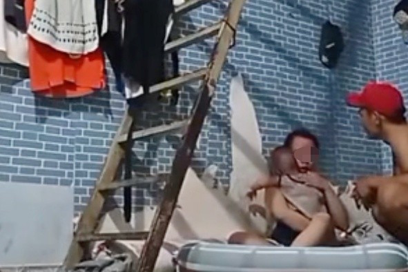 Người đàn ông ở TP.HCM livestream cảnh hành hung một cô gái ôm trẻ nhỏ. Ảnh cắt từ clip.